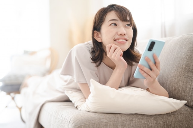 スマホを手に笑顔の女性