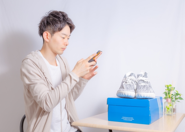 スニーカーを出品しようとしている男性